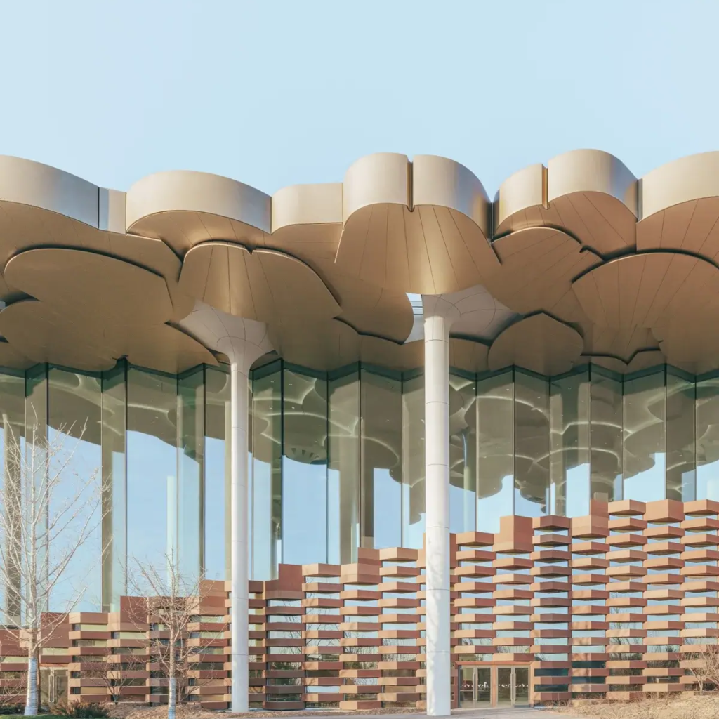 A wide-angle view of the Beijing City Library, showcasing the blend of modern glass curtain walls and LOPO's terracotta panels on the exterior facade, symbolizing the fusion of modernity and tradition.