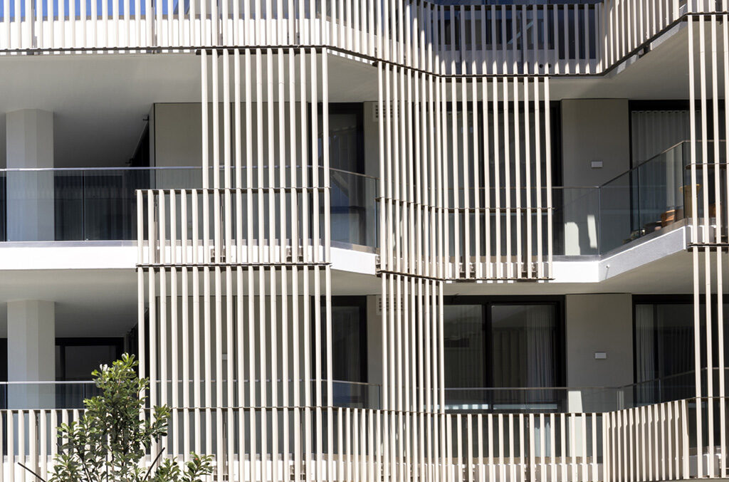 A detailed view of the LOPO Terracotta Baguettes installed on the building facade. The image highlights the precision alignment and natural texture of the terracotta elements, emphasizing their aesthetic appeal and functional role in shading and ventilation.