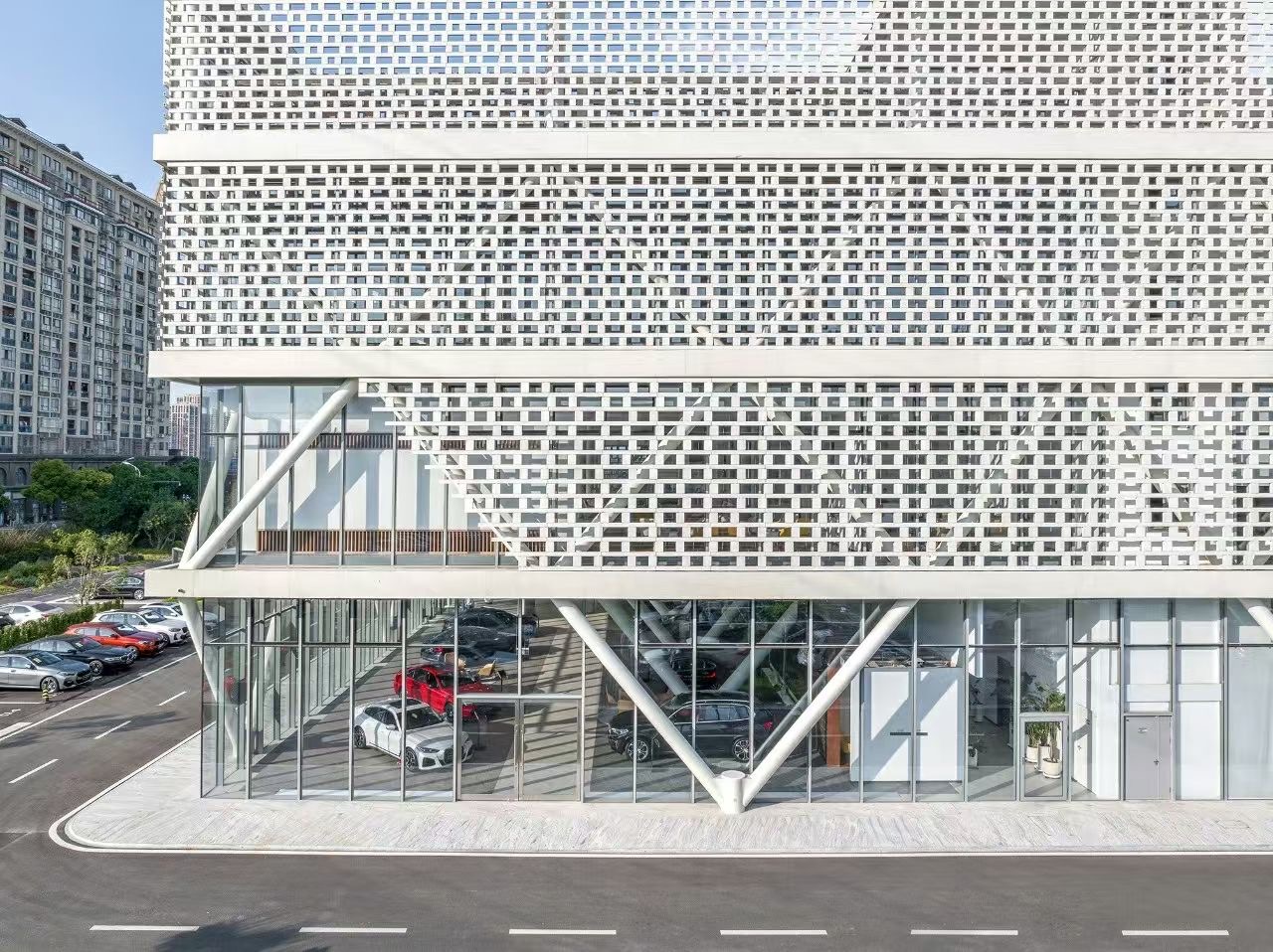 The front view of the Wuxi Xibaohang BMW 4S dealership, where LOPO white ceramic bricks create an elegant and modern appearance, in harmony with the building's surrounding environment.